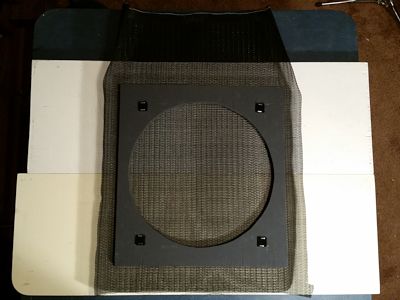 The speaker grille frame (back side facing up) was laid on the grille cloth.