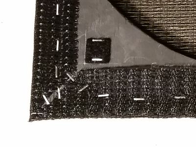 Close look at the trimmed grille cloth at a corner.
